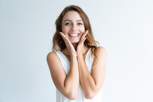 smiling-young-pretty-woman-looking-camera-touching-face_1262-15253